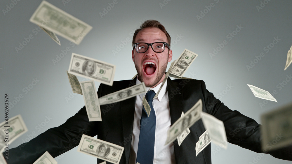 Close-up of screaming businessman with flying dollars banknotes Close-up of screaming businessman with flying dollars banknotes