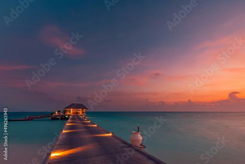 Fototapeta Naklejka Na Ścianę i Meble -  Amazing sunset panorama at Maldives. Luxury resort villas seascape with soft led lights under colorful sky. Beautiful twilight sky and colorful clouds. Beautiful beach background for vacation holiday