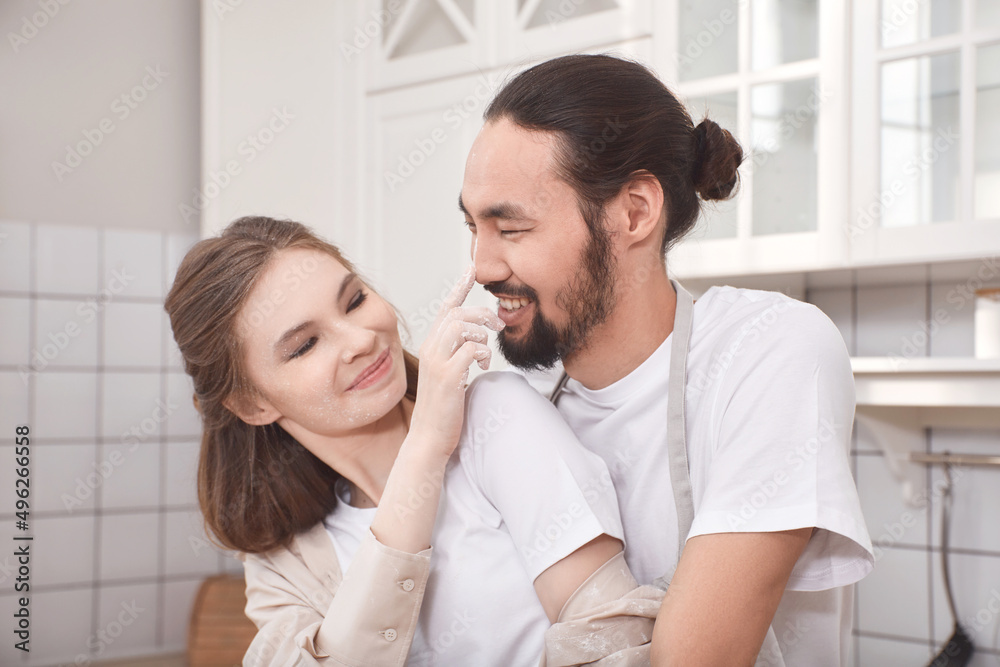 Loving young couple together at kitchen counter. Young man and woman in love cooking food together at home. Loving young couple together at kitchen counter. Young man and woman in love cooking food together at home.