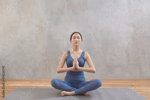 A young asian girl in lotus position meditate and do yoga. Mental health concept