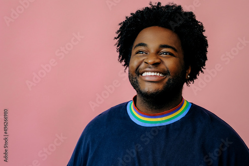 young happy african american man posing in the studio over pink background male model