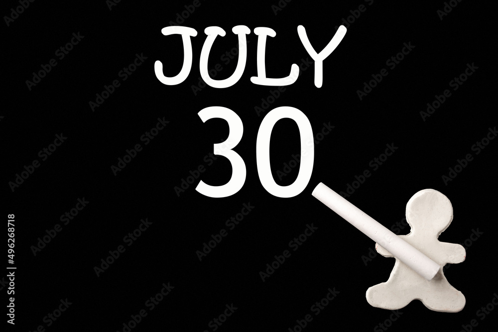 A small white plasticine man writing the date 30July on a black board. Business concept. Education concept. A small white plasticine man writing the date 30July on a black board. Business concept. Education concept.