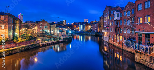 Cityscape and reflections in River Aire at night, Leeds, West Yorkshire, England, UK photo
