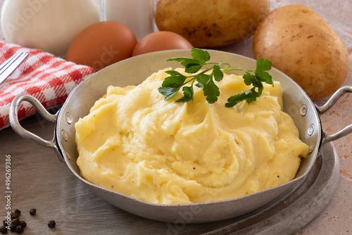 mashed potatoes in a dish with potatoes, milk, eggs on a table