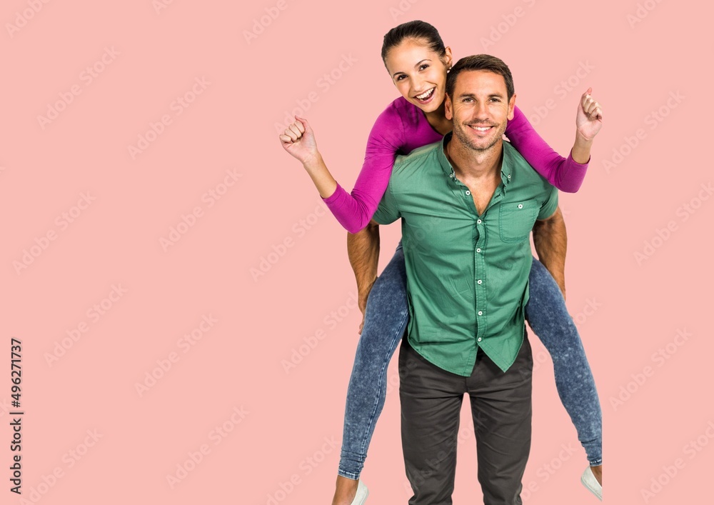 Portrait of caucasian man giving a piggy back ride to his wife against copy space on pink background Portrait of caucasian man giving a piggy back ride to his wife against copy space on pink background