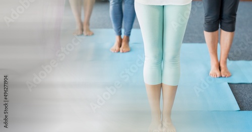 Blur effect with copy space against low section of people performing yoga at yoga studio