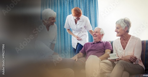 Blur effect with copy space against group of senior people having coffee together at retirement home