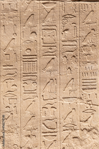 Ancient Egyptian murals and hieroglyphs on the stone walls of the Karnak Temple in Luxor, Egypt