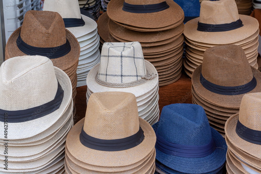 Stacks of mens hats on street counter.