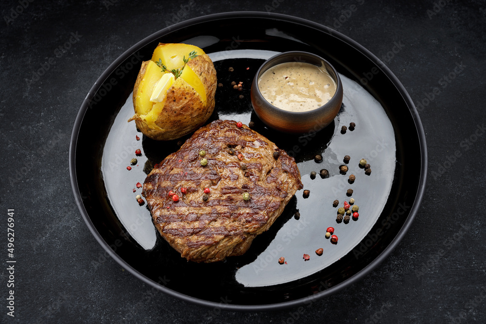 Grilled pork steak with baked potatoes, mustard sauce, pepper. Grilled pork steak with baked potatoes, mustard sauce, pepper.