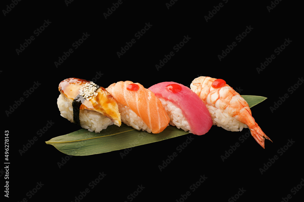 Nigiri sushi set nigiri eel, salmon, tuna, shrimp on a banana leaf. japanese food on isolated black background, japanese menu. Nigiri sushi set nigiri eel, salmon, tuna, shrimp on a banana leaf. japanese food on isolated black background, japanese menu.