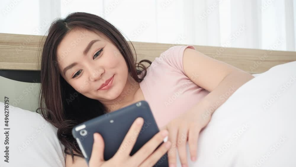 Asian young woman using tablet and life planning at home. Beautiful girl happy expression and enjoying with tablet in the morning at home. Asian young woman using tablet and life planning at home. Beautiful girl happy expression and enjoying with tablet in the morning at home.