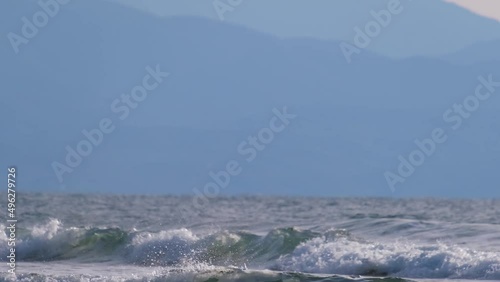 Atmospheric afternoon view of sea waves and mountains in the background at Ayia Eirini beach in Cyprus
 photo