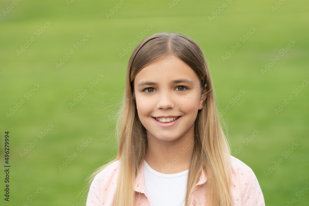 Portrait of happy girl child smiling on green grass background outdoors Portrait of happy girl child smiling on green grass background outdoors