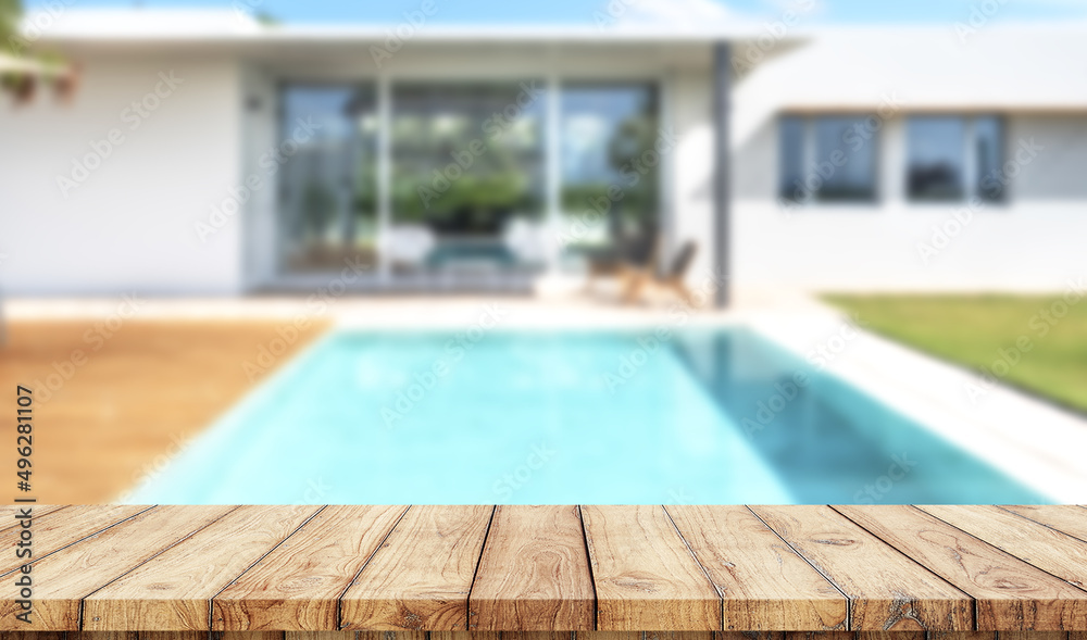 Empty wooden table with blurred luxury garden with swimming pool on background