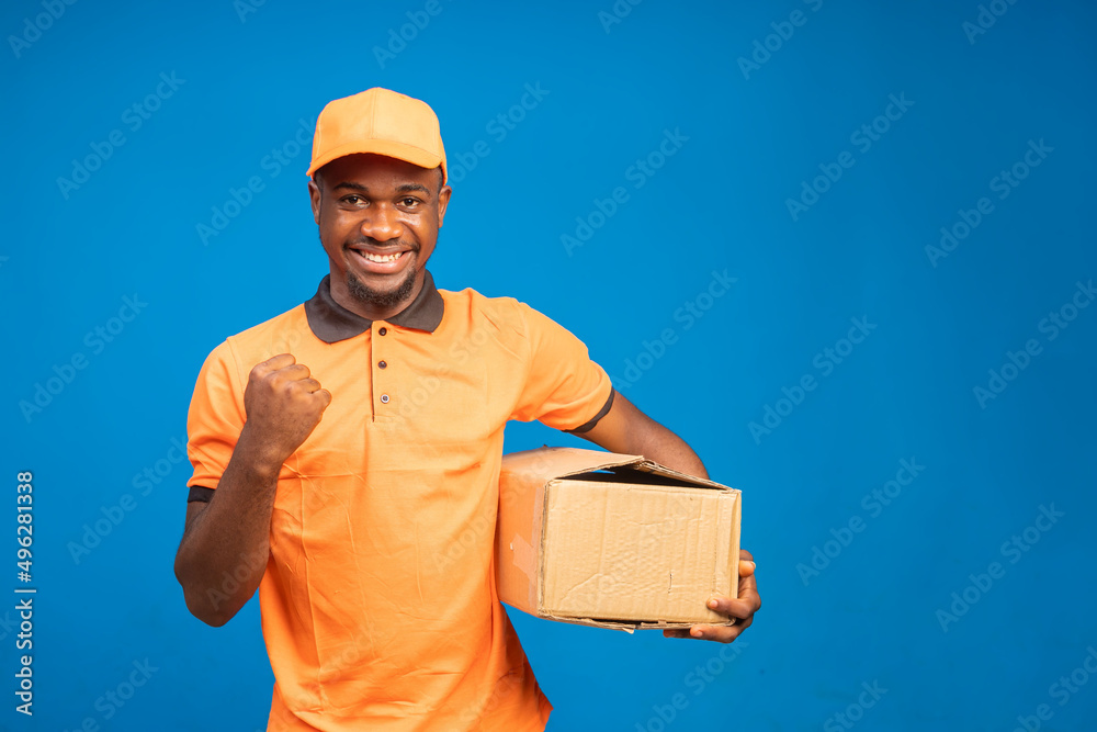 handsome african guy feeling excited as he holds the delivery package on his hand handsome african guy feeling excited as he holds the delivery package on his hand