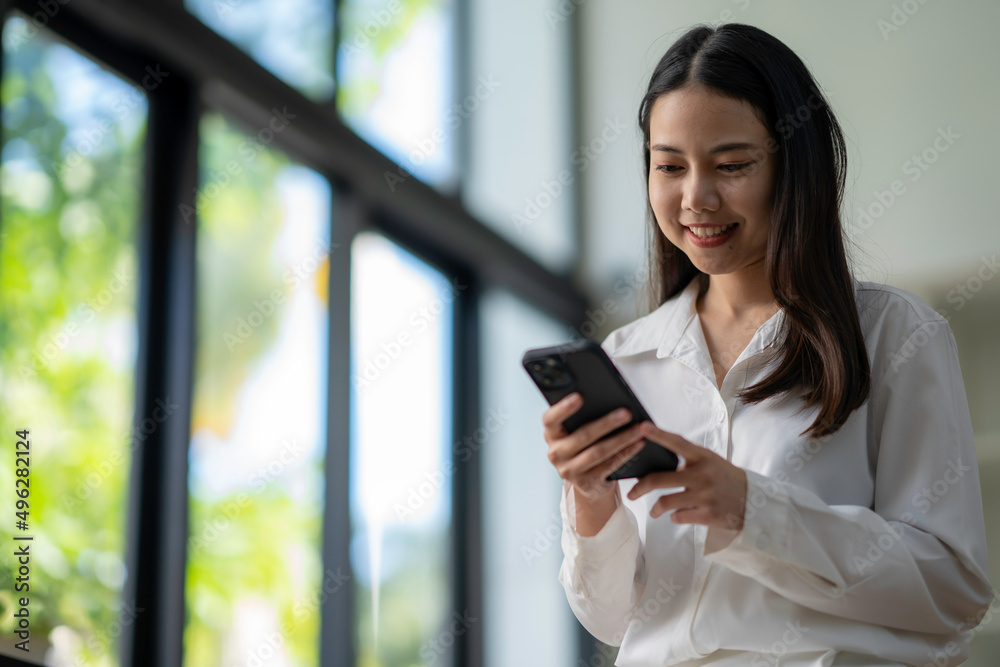 Attractive looking Asian business woman using a smartphone. to wipe email and work online via mobile Attractive looking Asian business woman using a smartphone. to wipe email and work online via mobile