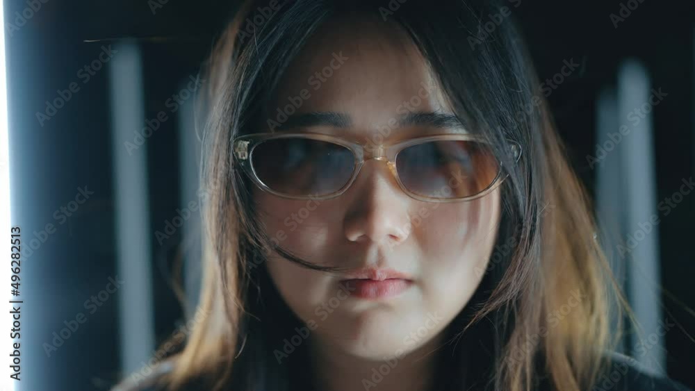 Close up portrait of young Asian woman wearing glasses looking camera with neon flashing lights background. Close up portrait of young Asian woman wearing glasses looking camera with neon flashing lights background.