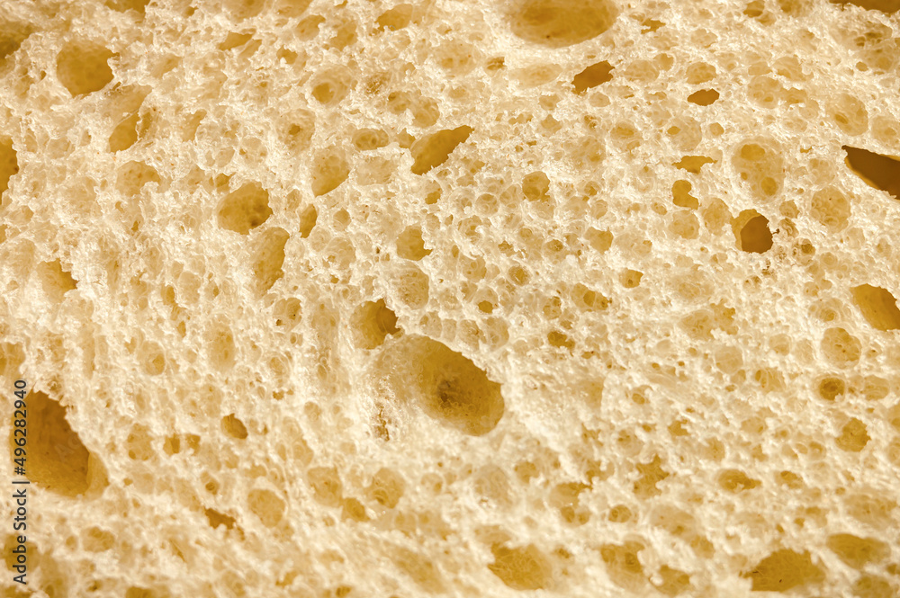 texture of white bread as a close up background. backdrop of rough dappled textured surface slice of loaf or sandwich dough of natural organic food with holes. top view