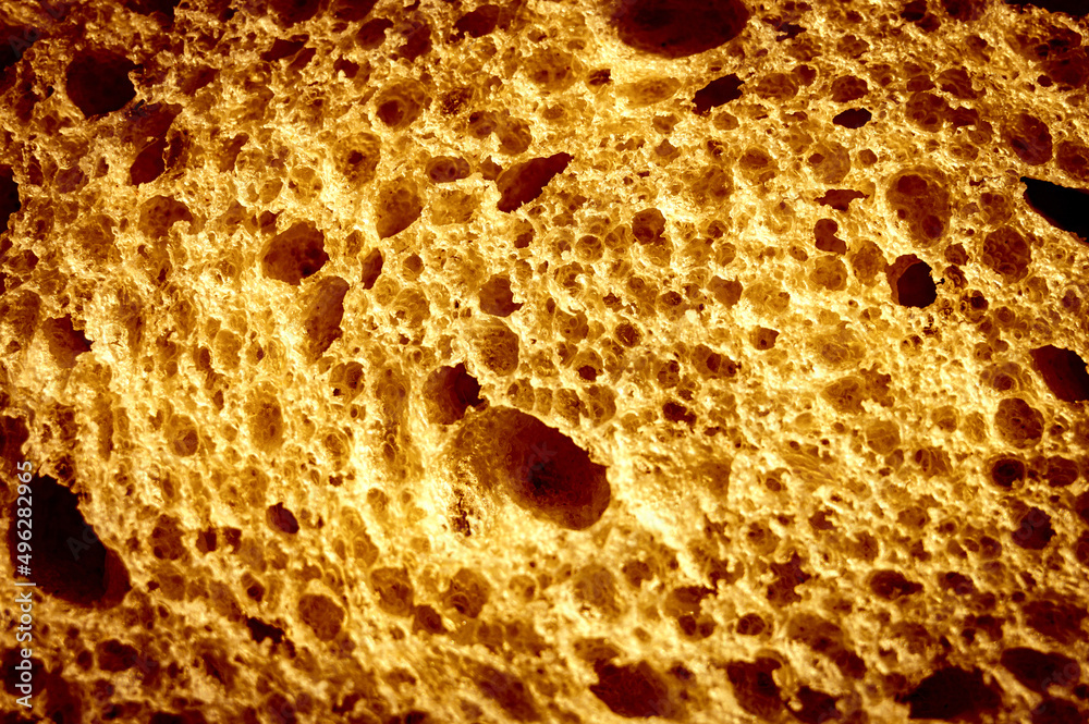 texture of brown bread as a close up background. backdrop of rough dappled textured surface crusty toasted slice of white loaf or sandwich toast of natural organic food with holes. top view texture of brown bread as a close up background. backdrop of rough dappled textured surface crusty toasted slice of white loaf or sandwich toast of natural organic food with holes. top view