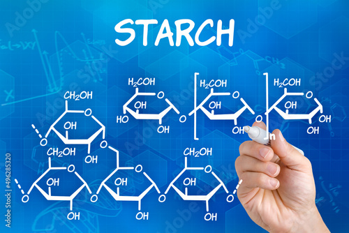 Hand with pen drawing the chemical formula of starch photo