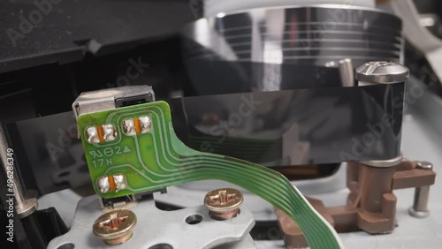 Running part pulls magnet tape to head of old videocassette recorder in room macro view. Vintage device to enjoy cinema at home. Technology service