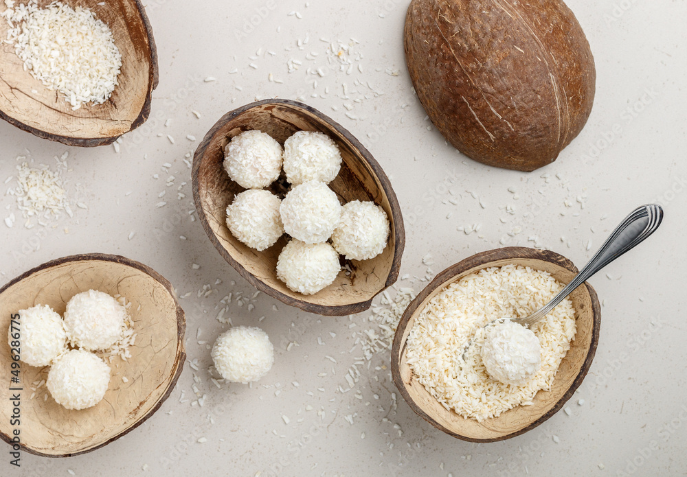 Homemade round candies made of coconut and white chocolate. Preparation of a delicious healthy dessert. Raffaello. Selective focus, top view Homemade round candies made of coconut and white chocolate. Preparation of a delicious healthy dessert. Raffaello. Selective focus, top view