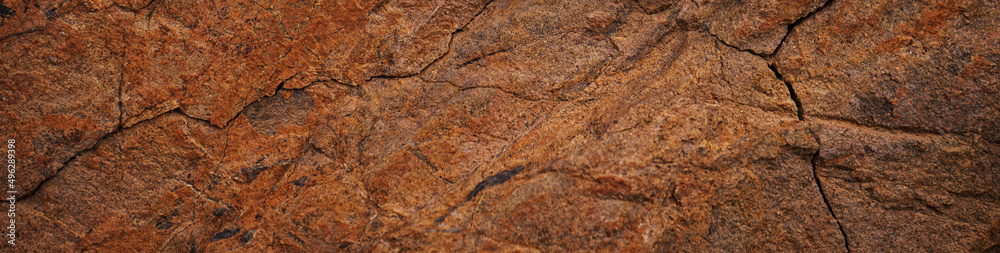 Red brown rock texture. Cracked mountain surface. Close-up. Stone background with space for design. Web banner. Red brown rock texture. Cracked mountain surface. Close-up. Stone background with space for design. Web banner.