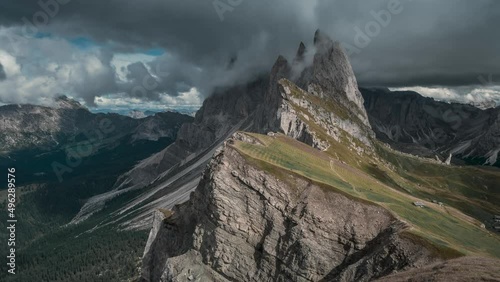 Timelaspe of dramatic mountain peaks of Seceda with clouds in the European Dolomite Alps, meadow in the foreground, steep cliff, South Tyrol Italy
