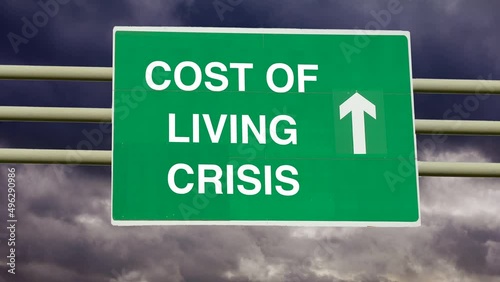 Money costs and financial problems. Zoom in to a Cost of Living Crisis road sign with time lapse clouds background. photo