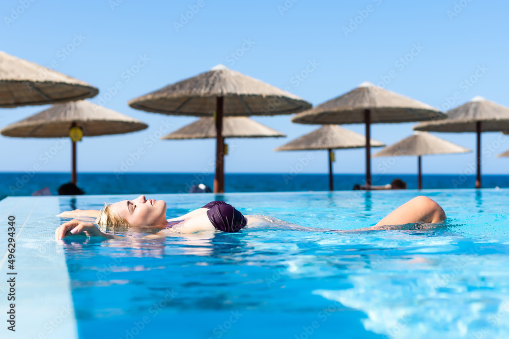 Sexy woman in bikini is posing in the swimming pool. Wellness and spa luxury resort. Sexy woman in bikini is posing in the swimming pool. Wellness and spa luxury resort.
