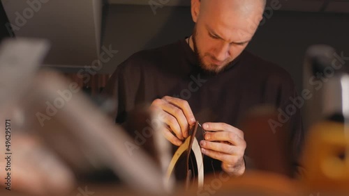 tanner makes leather product, purse. With your own hands, DIY instruction, indoor, closeup, lifestyle, authentic. Eco production, entrepreneur. sews with threads