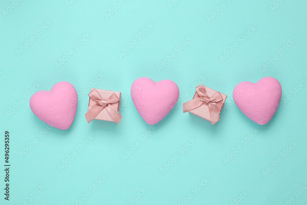 Fototapeta premium Gift boxes with hearts on a blue background. Love concept. Top view
