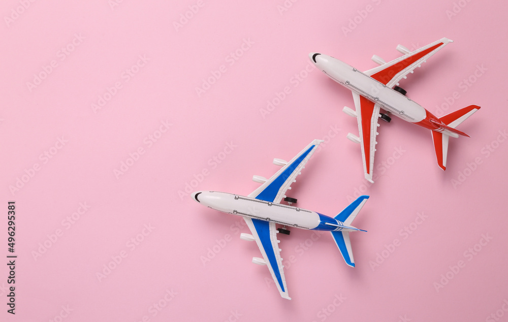 Two Toy model airplanes on pink background. Travel concept. Flat lay, top view