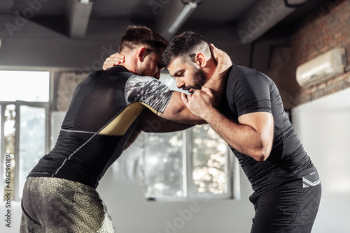 Sparring training of two athletic mma fighters in the gym. Martial arts, Wrestling photo