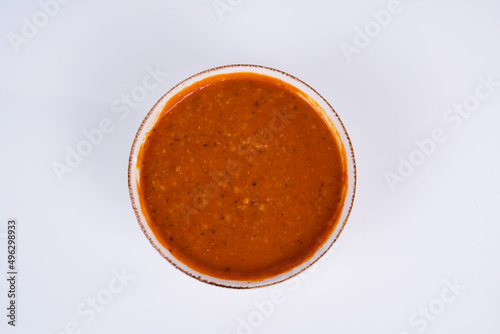Cropped view of ezogelin soup shot from an overhead angle on an isolated white background.