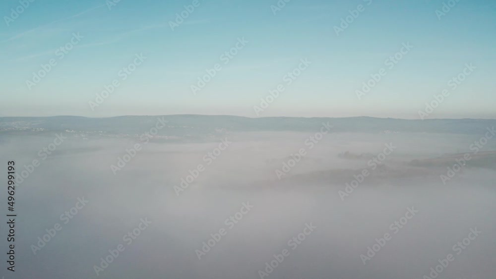AERIAL: Slow rise up through cloud inversion revealing valley and hills covered in fog, Gower, 4k Drone AERIAL: Slow rise up through cloud inversion revealing valley and hills covered in fog, Gower, 4k Drone