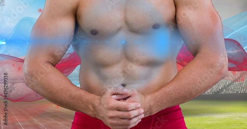 Mid section of caucasian fit man flexing against digital waves and sports field