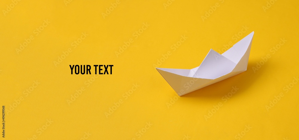 Paper origami boat on yellow background. Space for your text - obrazy, fototapety, plakaty 