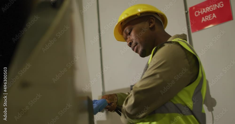 African american male worker wearing safety suit with helmet in warehouse African american male worker wearing safety suit with helmet in warehouse