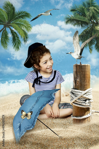 Little girl with a smile on her face, sitting on the sea beach, looks at the seagull