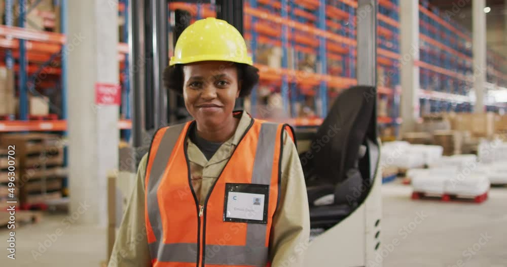 Portrait of african american female worker wearing safety suit and smiling in warehouse Portrait of african american female worker wearing safety suit and smiling in warehouse