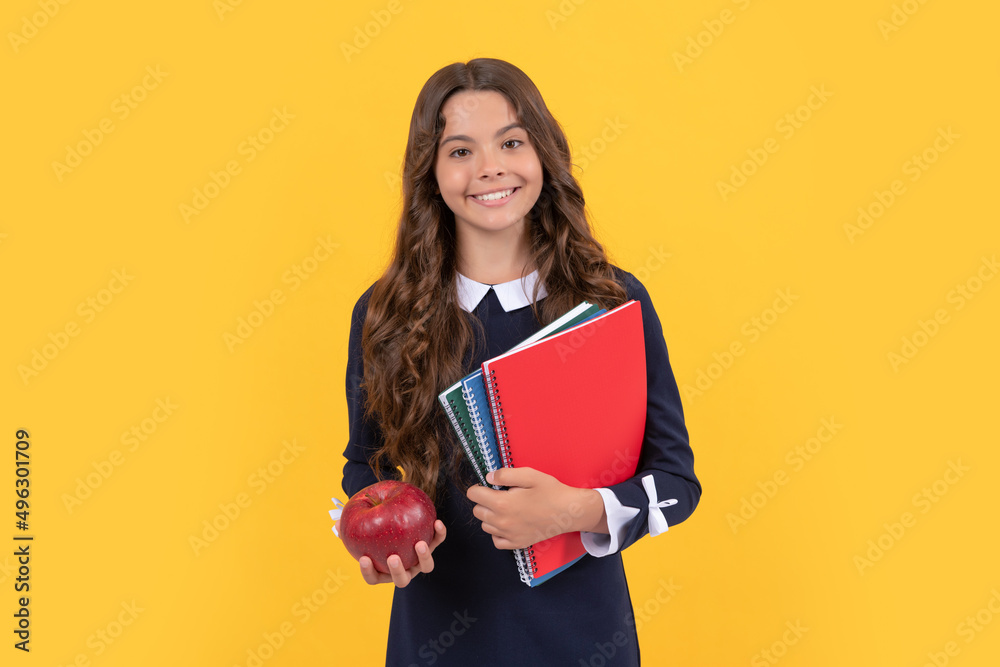 cheerful child hold school copybooks for homework and apple lunch on yellow background, lunch cheerful child hold school copybooks for homework and apple lunch on yellow background, lunch