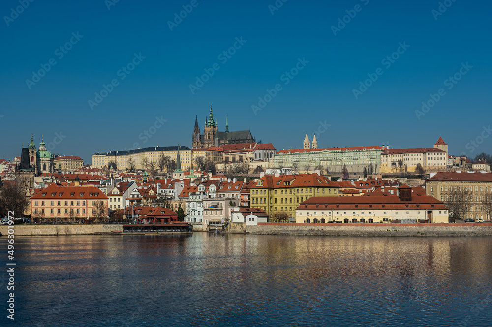 Old town of Prague. Czech Republic over the Vltava River with St. Vitus Cathedral on the horizon. Bright sunny day blue sky.