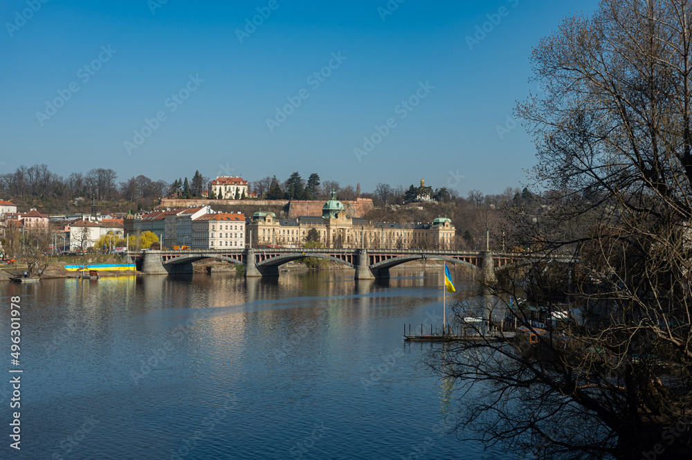Prague, Czech Republic view of the Vltava river on the Manes bridge. The end of March. River banks in Ukrainian flags.