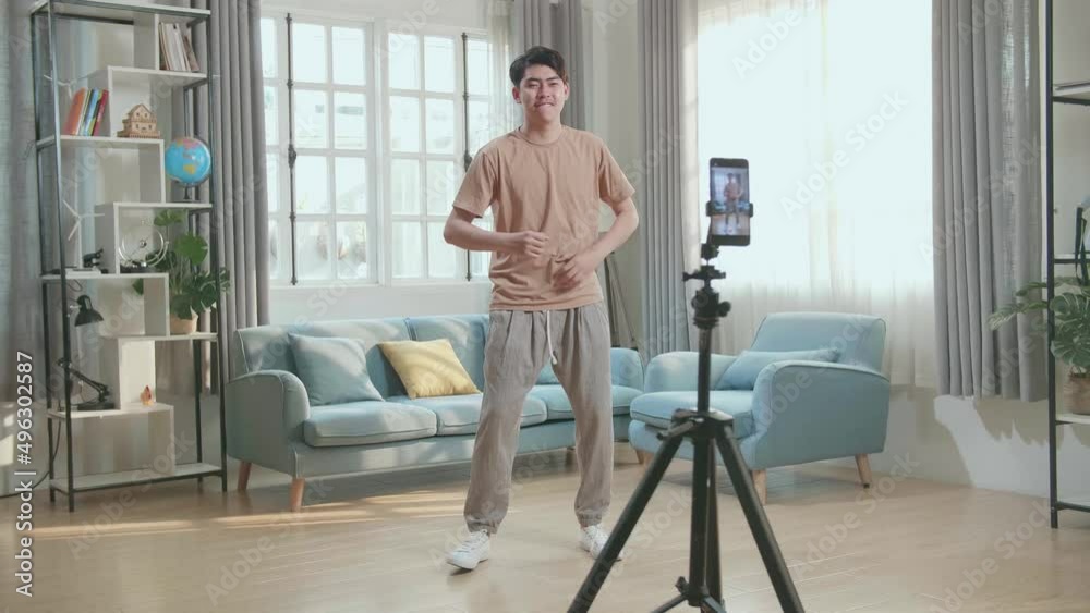 Asian Man Dancing While Shooting Video Content For Social Networks With A Smartphone Camera
Asian Man Dancing While Shooting Video Content For Social Networks With A Smartphone Camera