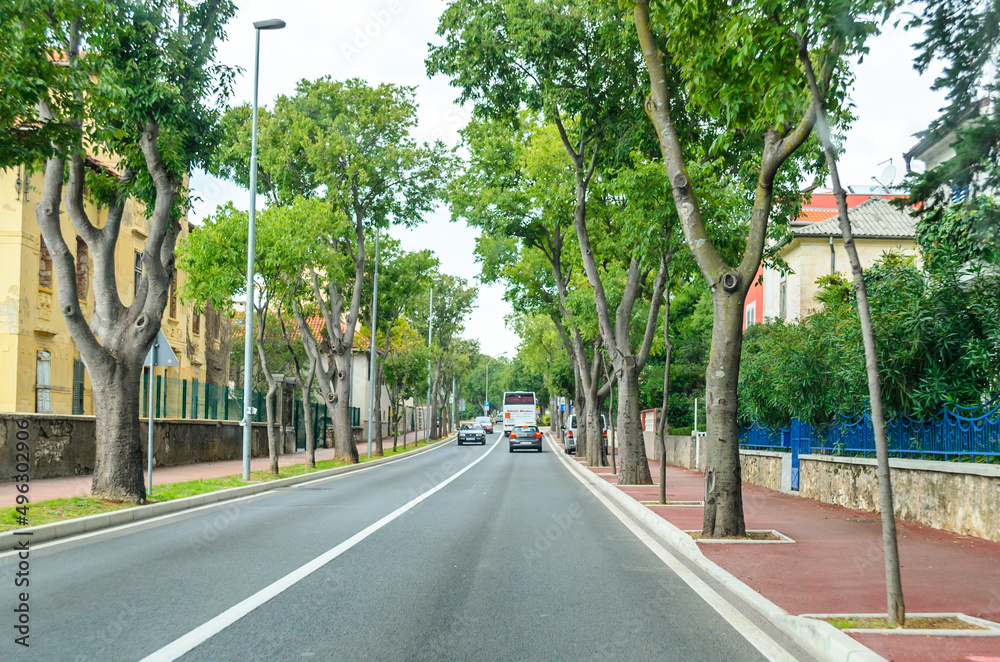 Narrow Straight Highway Road with Vehicles Crossing the a Beautiful Peaceful Town in Croatia. Narrow Straight Highway Road with Vehicles Crossing the a Beautiful Peaceful Town in Croatia.