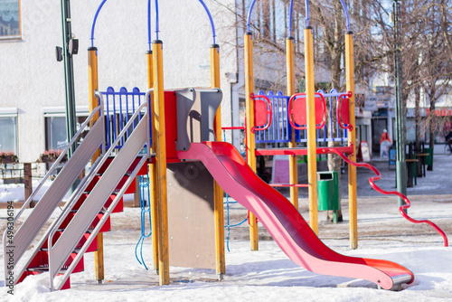 children playground with slide  in winter in european city