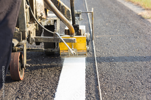 Machine eject and worker on road and traffic sign painting
