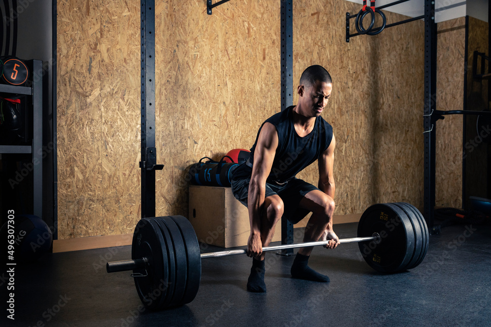 Black sportsman lifting barbell in gym Black sportsman lifting barbell in gym